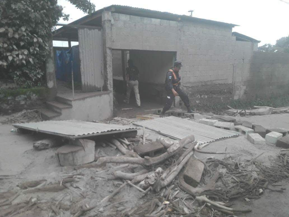 Autoridades buscan sobrevivientes en casas cubiertas de ceniza.
Fotografía por Bomberos Municipales Departamentales E-02